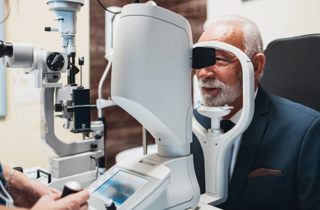 A senior man getting his eyes checked by an eye doctor using a medical equipment.