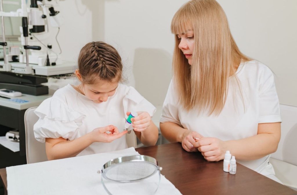 A young child learns how to insert their contact lens safely during a fitting appointment.