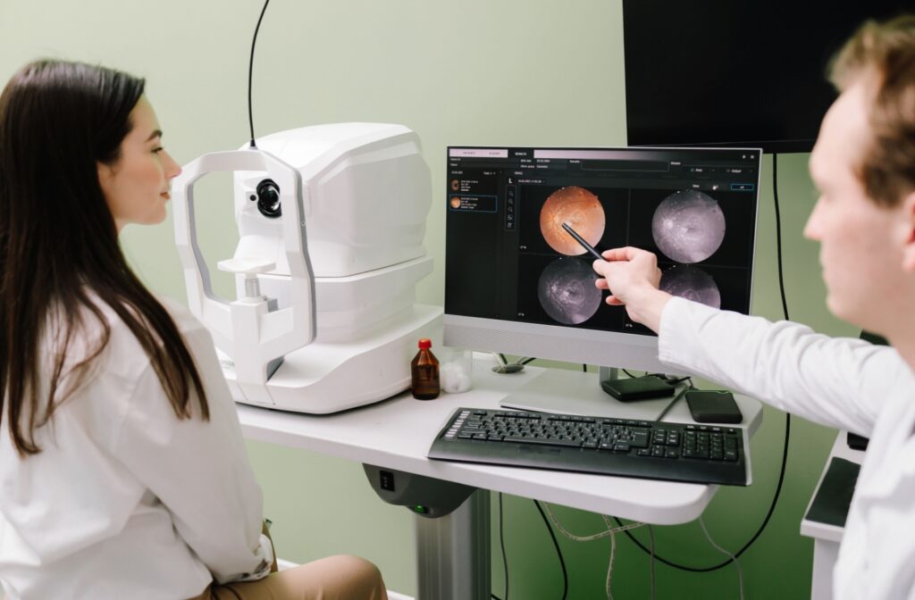 Optician showing a patient retinal scans on a computer screen, discussing results from an OCT scan during a diabetic eye exam.