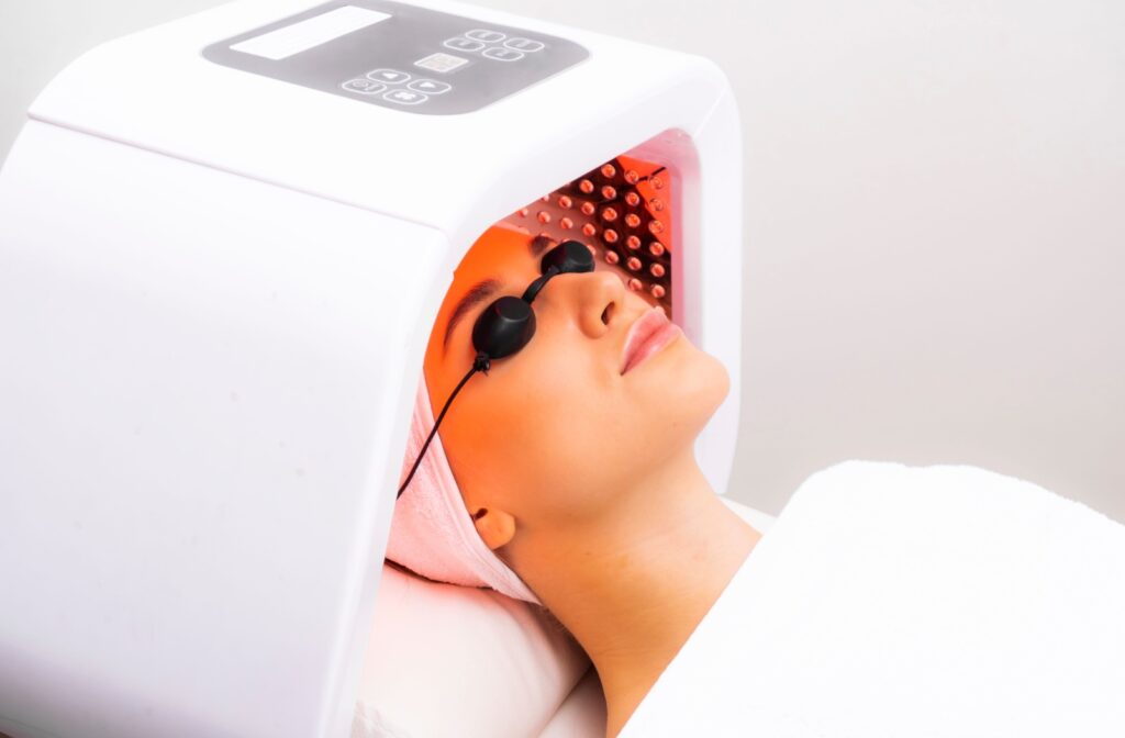 A person wearing eye protection goggles while using red light therapy